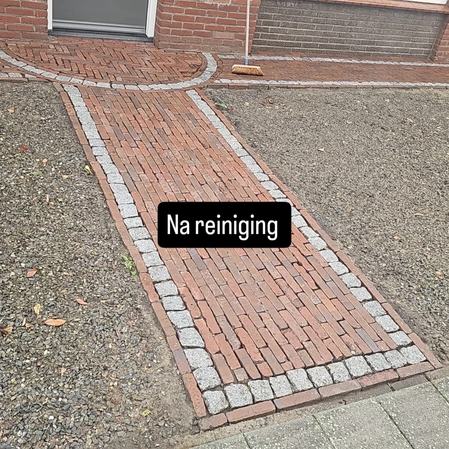 Bakstenen tuinpad na de reiniging, de stenen zijn weer rood en de rand grijs
